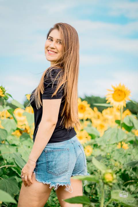 foto de perfil de uma mulher no campo de girassóis da alta genetics do brasil'