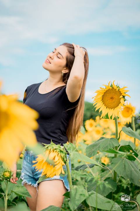 foto de perfil de uma mulher no campo de girassóis da alta genetics do brasil'
