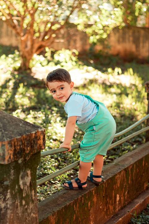 menino muito esperto brincando de pular a mureta '