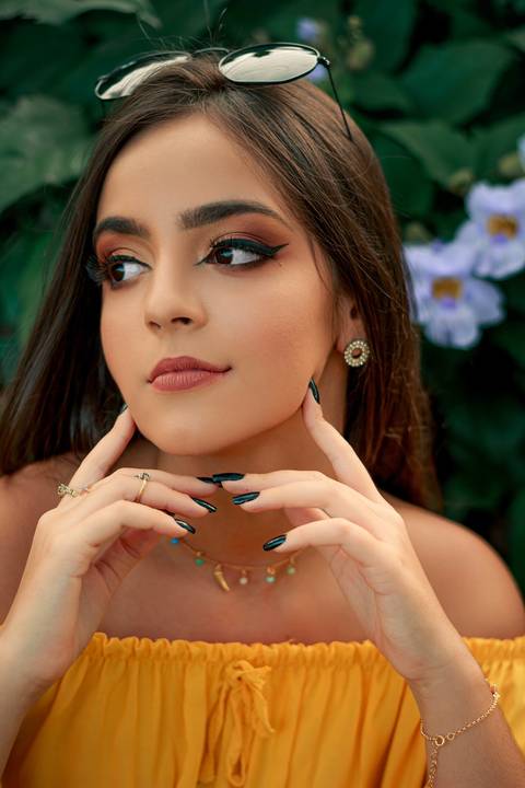 menina de 15 anos pensativa em meio ás flores roxas'