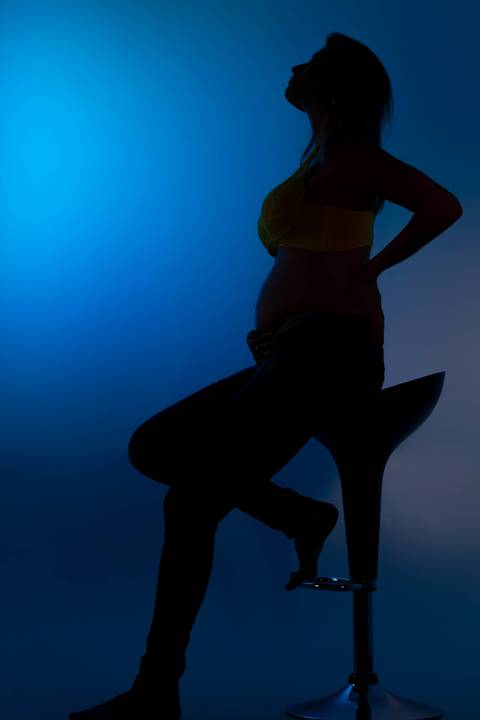 silhueta de gestante com fundo azul'