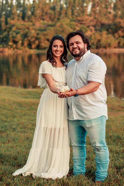 casal segurando sapatinho de bebe '