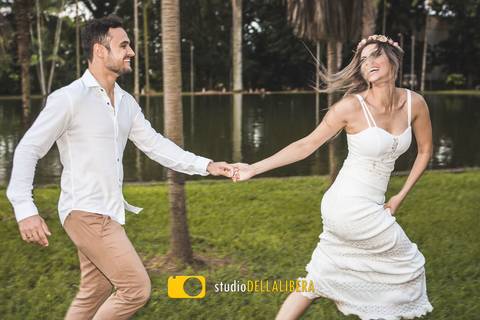 Noivos correndo ao redor de um lago, na sessão fotografica do pre-weeding de Carol e Rodrigo, noiva com cabelos esvoaçantes'