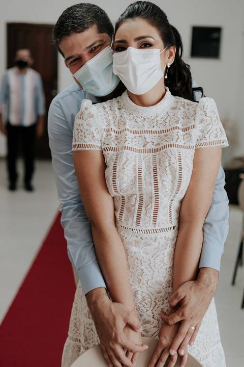 Noivos abraçados enquanto esperam o juiz de paz'