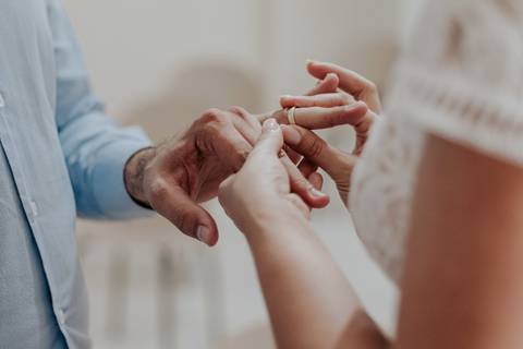 Mãos e alianças sendo colocada'