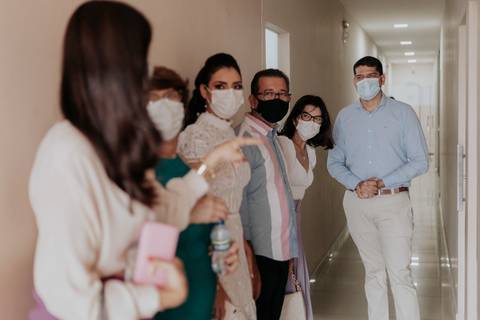 Convidados rindo enquanto esperam no corredor para o casamento'