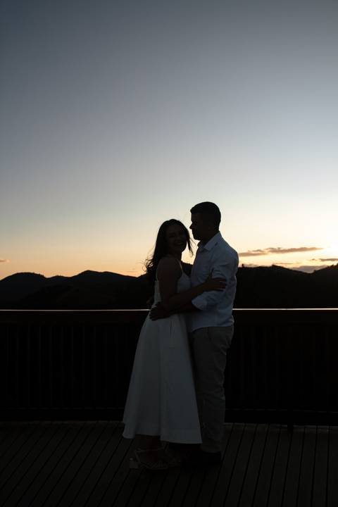 Casal durante ensaio fotográfico no Pico do Itapeva ao pôr do sol com atmosfera leve.'