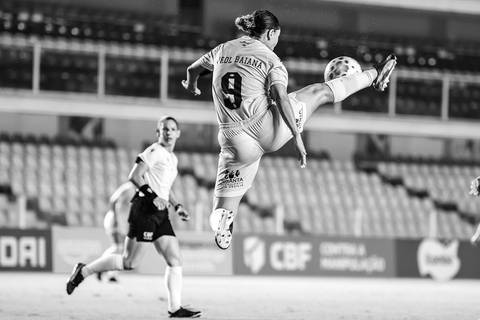 Carol Baiana fazendo acrobacia para dominar a bola'