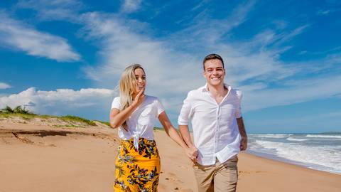 noivos correndo na praia'