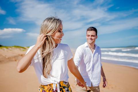 noivos correndo na praia, em fotografia pre weddin'