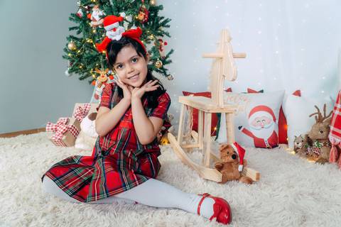 Ensaio de Natal em Família em Piraquara e Curitiba Paraná. Menina no cenário natalino com enfeites, brinquedos e arvore de natal.'