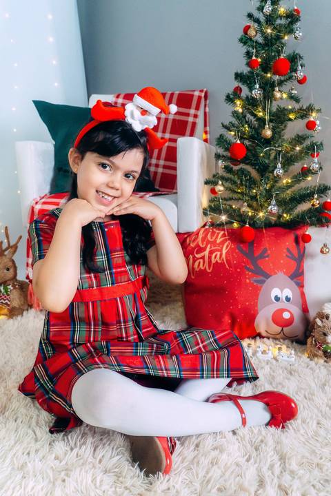 Ensaio de Natal em Família em Piraquara e Curitiba Paraná. Menina no cenário natalino com enfeites, brinquedos e arvore de natal.'