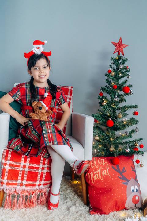 Ensaio de Natal em Família em Piraquara e Curitiba Paraná. Criança no cenário natalino com enfeites e arvore de natal.'
