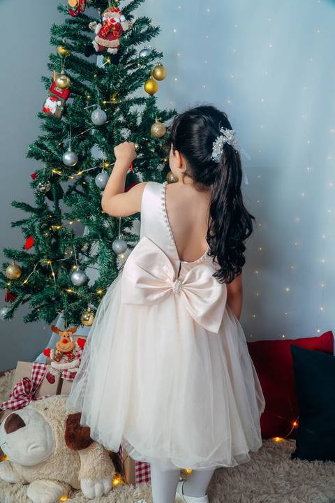 Ensaio de Natal em Família em Piraquara e Curitiba Paraná. Menina no cenário natalino com enfeites e arvore de natal.'