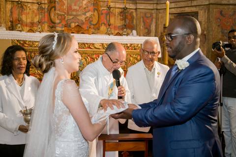 fotografia da cerimônia dos noivos Camila e Roberto na Igreja do Rosário com os noivos Camila e Roberto em Ouro Preto Minas Gerais padre abençoando o casal'