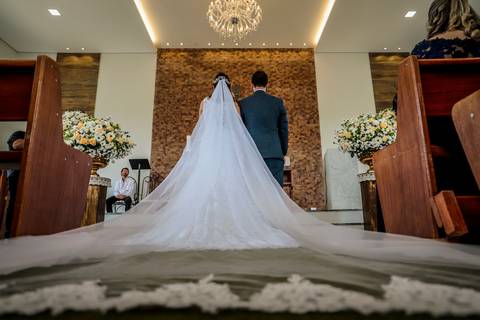 noivos mélani e pedro durante celebração de casamento com o padre na cidade de piracema minas gerais , vestido de noiva'