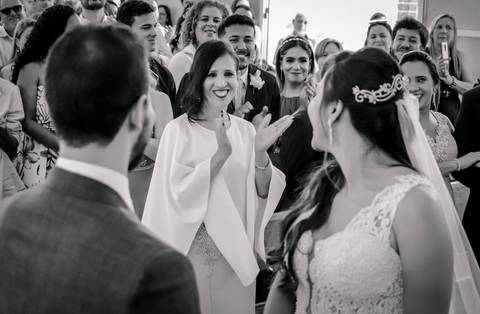 noivos mélani e pedro durante celebração de casamento com o padre na cidade de piracema minas gerais, com os olhares atentos de sua mãe'