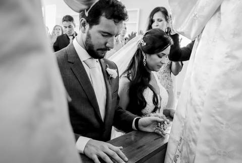 noivos mélani e pedro durante celebração de casamento com o padre na cidade de piracema minas gerais, durante a benção dos pais'