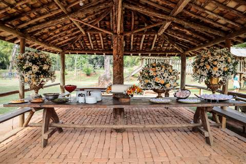 noivos mélani e pedro durante celebração de casamento com o recepção do casamento de mélani e pedro na fazenda engenho em piracema minas gerais , mesa de bolo
'