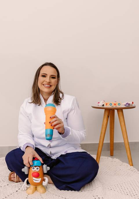 Ensaio corporativo Renata Bridges Fonoaudióloga infantil criança calça azul blusa bordada foto de estúdio bom despacho'