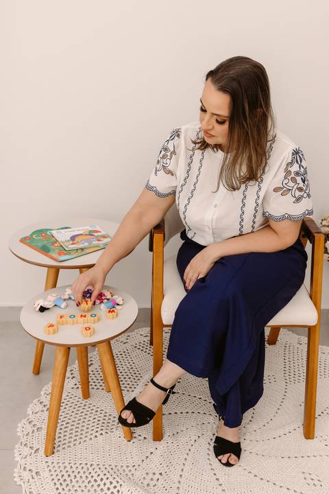 Ensaio corporativo Renata Bridges Fonoaudióloga infantil criança calça azul blusa bordada foto de estúdio bom despacho'