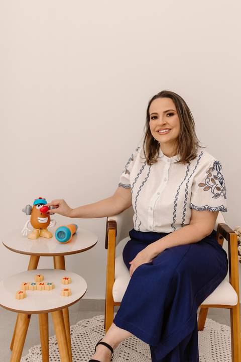 Ensaio corporativo Renata Bridges Fonoaudióloga infantil criança calça azul blusa bordada foto de estúdio bom despacho'