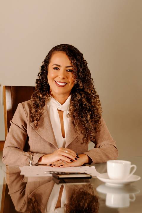 ensaio em casa fotos corporativas bom despacho renata bridges blazer marrom blusa branca cabelo cacheado make dia xícara branca computador quarto notebook look preto'