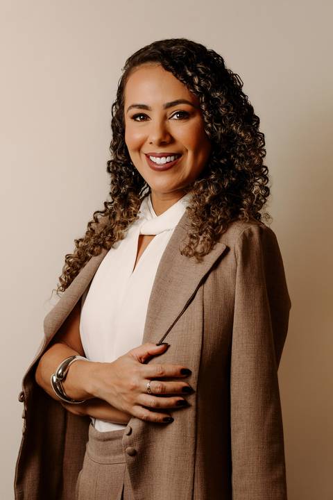 ensaio em casa fotos corporativas bom despacho renata bridges blazer marrom blusa branca cabelo cacheado make dia xícara branca computador quarto notebook look preto'