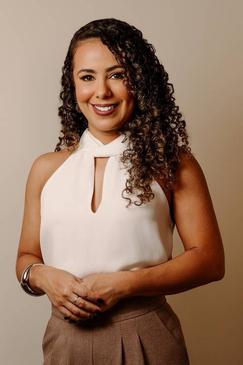 ensaio em casa fotos corporativas bom despacho renata bridges blazer marrom blusa branca cabelo cacheado make dia xícara branca computador quarto notebook look preto'