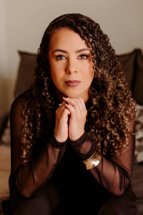 ensaio em casa fotos corporativas bom despacho renata bridges blazer marrom blusa branca cabelo cacheado make dia xícara branca computador quarto notebook look preto'