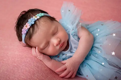 Bebê Helena, com vestido azul de estrelas e faixinha de flores no ensaio newborn no estúdio da fotógrafa Carol Zimmermann'