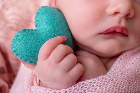 Detalhes: uma mãozinha tão pequena segurando um coração verde. Sua boca e nariz mostram sua delicadeza e beleza!'