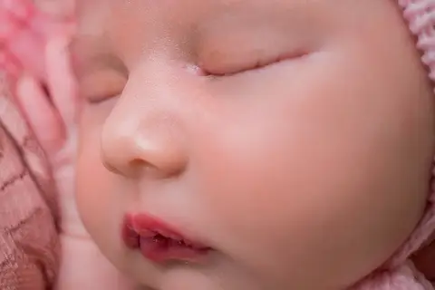 Detalhes do rosto da bebê, olhos, nariz, boca e mão, além das bochechas. Delicadeza no ensaio newborn da bebê Helena. Foto pela fotógrafa Carol Zimmermann'