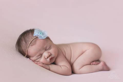 bebê recem nascido na pose do bumbum fundo rosa e headband flor azul brasília'