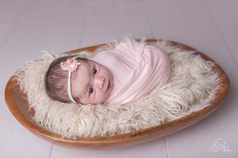 newborn recem nascido na gamela wrap rosa e fundo de madeira brasília'