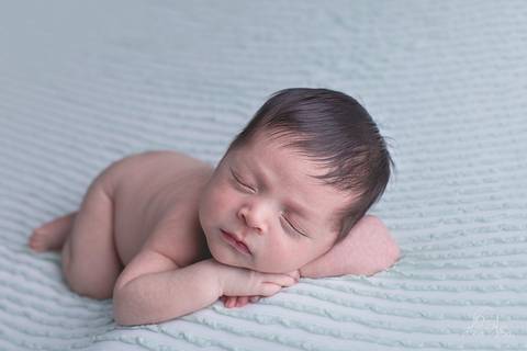 ensaio newborn em brasilia Pose mão no queixo no ensaio newborn do Davi manta verde com branco'