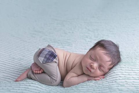 pose do bumbum ensaio newborn do Davi com manta verde clara e calça marrom ensaio newborn em brasilia'