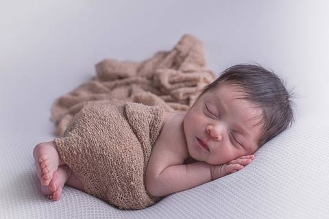 ensaio do Davi newborn pose de lado com manta branca e wrap marromensaio newborn em brasilia'