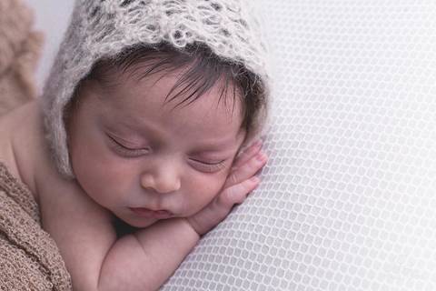 ensaio newborn em brasilia  close no Davi no ensaio newborn manta branca e touca'