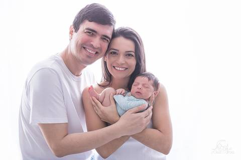 ensaio newborn em brasilia ensaio newborn foto com a familia do recem nascido todos de branco e o bebe de verde'