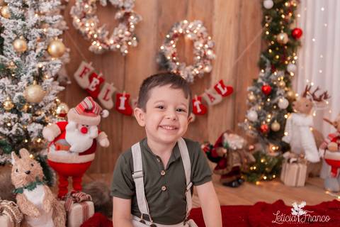 criança sorrindo cenário de madeira de natal'