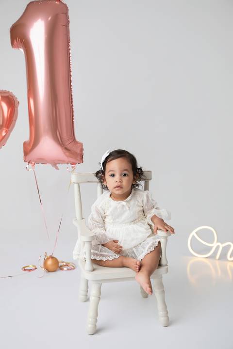 Desenvolvimento saudável e expressões espontâneas de bebê de um ano em Brasília - DF. Fotografia afetiva infantil focada no bem-estar e na pureza da infância.'