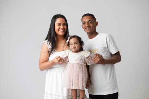 Laços de afeto e proteção familiar com a bebê Maitê e seus pais em Brasília, Distrito Federal. O aconchego e a união no primeiro aniversário da filha.'