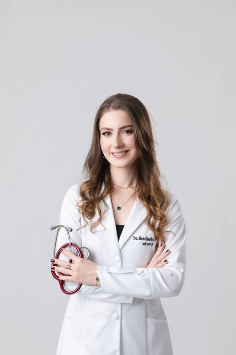 Ensaio de formatura de Medicina. A formanda Maria Eduarda de jaleco oficial e estetoscópio para fotos de posicionamento de imagem e CRM.'