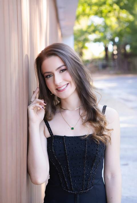 Fotos externas de formatura com luz natural. Maria Eduarda em retratos espontâneos celebrando a conquista do diploma de Medicina.'
