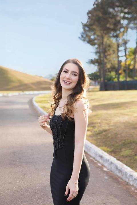 Fotos externas de formatura com luz natural. Maria Eduarda em retratos espontâneos celebrando a conquista do diploma de Medicina.'