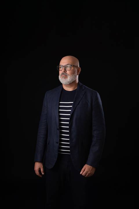 Ensaio corporativo masculino com fundo escuro. Retrato de estúdio elegante e de alto contraste focado em autoridade e liderança profissional.'