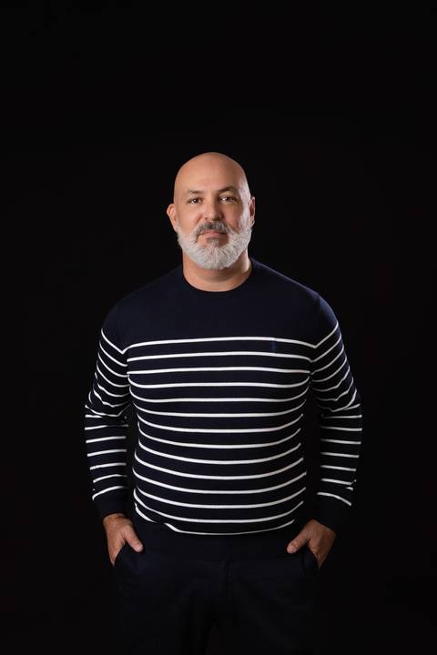 Retrato profissional casual masculino. Foto em estúdio com fundo escuro para comunicação moderna, palestras e redes sociais.'