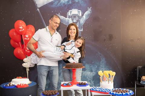Retrato de família e laços de afeto na celebração de 6 anos da Anna. O carinho e a união dos pais e convidados durante o momento dos parabéns.'