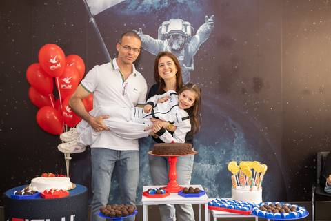 Retrato de família e laços de afeto na celebração de 6 anos da Anna. O carinho e a união dos pais e convidados durante o momento dos parabéns.'